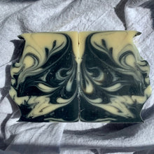 Load image into Gallery viewer, Black and white marbled soap bar on a textured fabric background